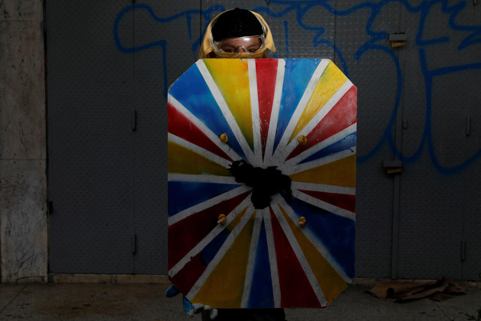 <p>A demonstrator holding a rudimentary shield poses for a picture before a rally against Venezuelan President Nicolas Maduro’s government in Caracas, Venezuela, June 17, 2017. He said: “I protest for a better future for my daughter and for a better Venezuela.” (Photo: Carlos Garcia Rawlins/Reuters) </p>