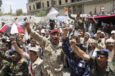 Army and police officers shout slogans during a protest to denounce fuel prices hikes and to demand for the resignation of the government in Sanaa August 22, 2014. RUETERS/Mohamed al-Sayaghi