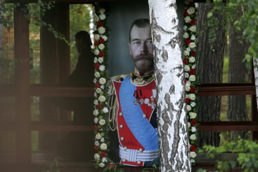 Russian Orthodox priest walks close to a portrait of the last Russian tsar, Nicholas II during as he takes part in the nightime procession