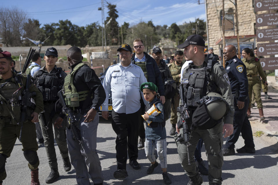 Israeli Minister of National Security Itamar Ben-Gvir, center, dressed in a costume combining elements of various uniforms of forces under his command, celebrate the Jewish holiday of Purim with security forces around him, in the West Bank city of Hebron, Tuesday, March 7, 2023. Ben-Gvir danced, sang, and took selfies with partygoers and soldiers at an event in an Israeli settlement in Hebron. Ben-Gvir, an ultranationalist politician in Benjamin Netanyahu's new government, lives in an adjacent settlement. The Jewish holiday of Purim commemorates the Jews salvation from genocide in ancient Persia, as recounted in the Book of Esther. (AP Photo/Ohad Zwigenberg)