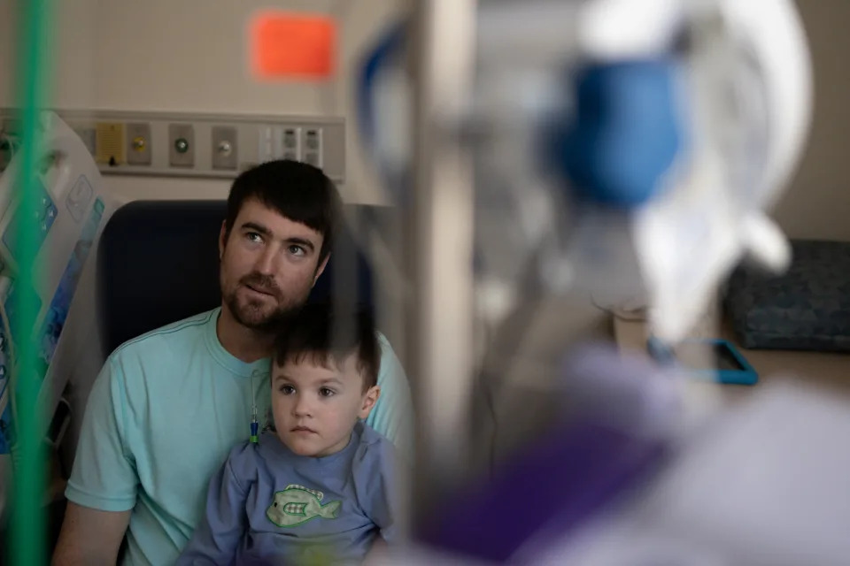 Brayden Burton, 3, sits with his father, Grant Burton, while he is treated for COVID at the Children's Hospital of Georgia in Augusta, Georgia, January 14, 2022. REUTERS/Hannah Beier