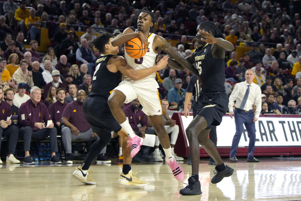 Arizona State guard Jamiya Neal (5) drives between Colorado guard KJ Simpson (2) and forward Assane Diop, front right, during the second half of an NCAA college basketball game, Saturday, Jan. 6, 2024, in Tempe, Ariz. (AP Photo/Rick Scuteri)