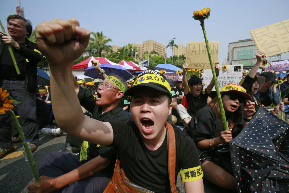 Protesters shout slogans denouncing the controversial China Taiwan trade pact during a massive protest in front of the Presidential Building in Taipei, Taiwan, Sunday, March 30, 2014. Over a hundred thousand protesters gathered in the demonstration against the island's rapidly developing ties with the communist mainland. (AP Photo/Wally Santana)