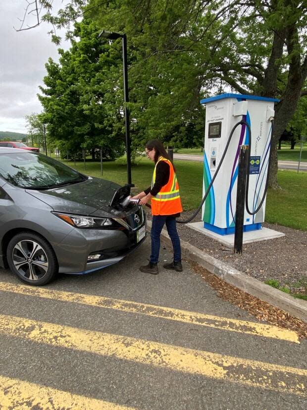 Rebecca Costello, an engineer at Nova Scotia Power, plugs an electric car into a bidirectional charger at the Nova Scotia Community College campus in Middleton, N.S. It's part of a pilot project testing the integration of electric vehicles into the grid. (Nova Scotia Power - image credit)