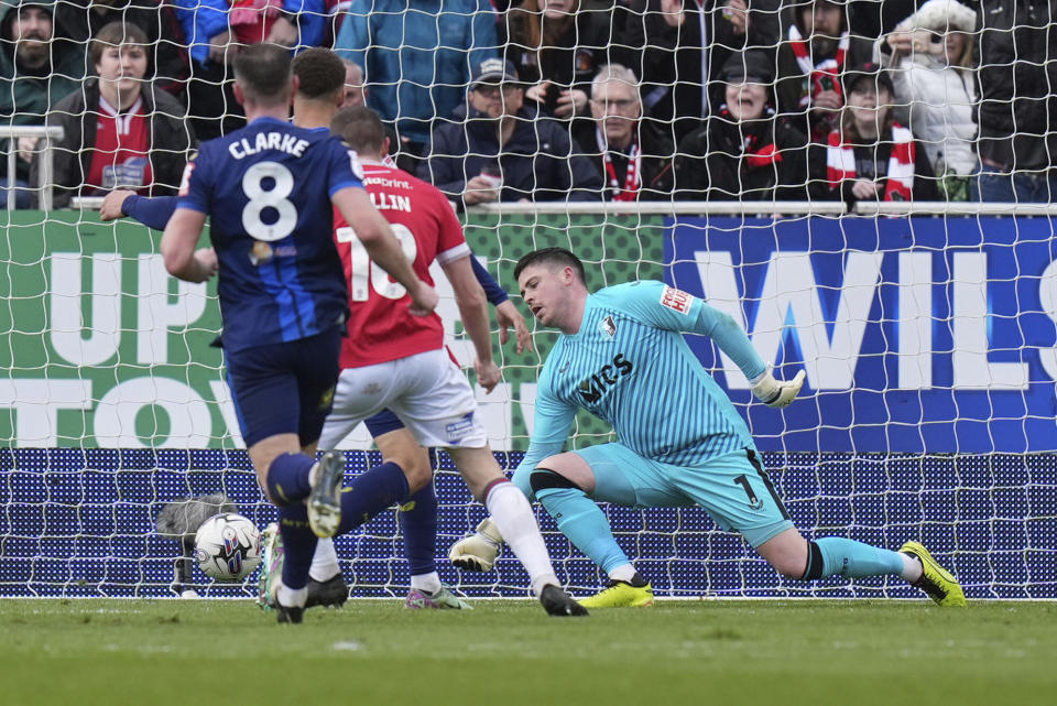 Wrexham's Paul Mullin scores the opening goal past Mansfield Town's goalkeeper Christy Pym, right, during the English League Two soccer match between Wrexham and Mansfield Town at the SToK Cae Ras in Wrexham, Wales, Friday, March 29, 2024. (Jacob King/PA via AP)