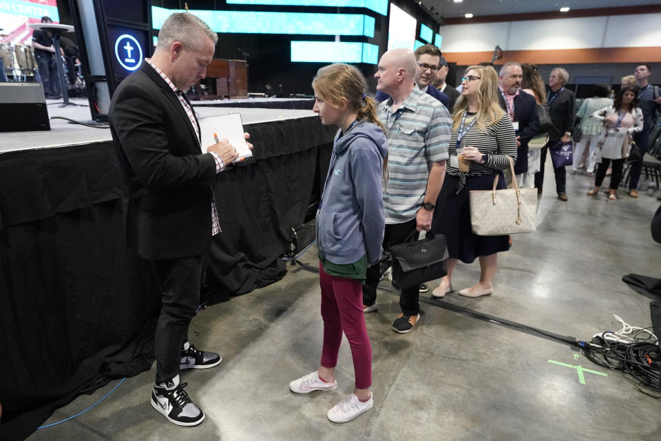 Outgoing Southern Baptist Convention President J. D. Greear, left, autographs a book after the denomination's annual meeting adjourned Wednesday, June 16, 2021, in Nashville, Tenn. (AP Photo/Mark Humphrey)