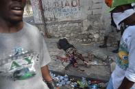 <p>A wounded man lies on a road following clashes with Haitian Police during a protest against the increase in fuel prices, July 7, 2018 in Port-au-Prince. (Photo: Hector Retamal/AFP/Getty Images) </p>