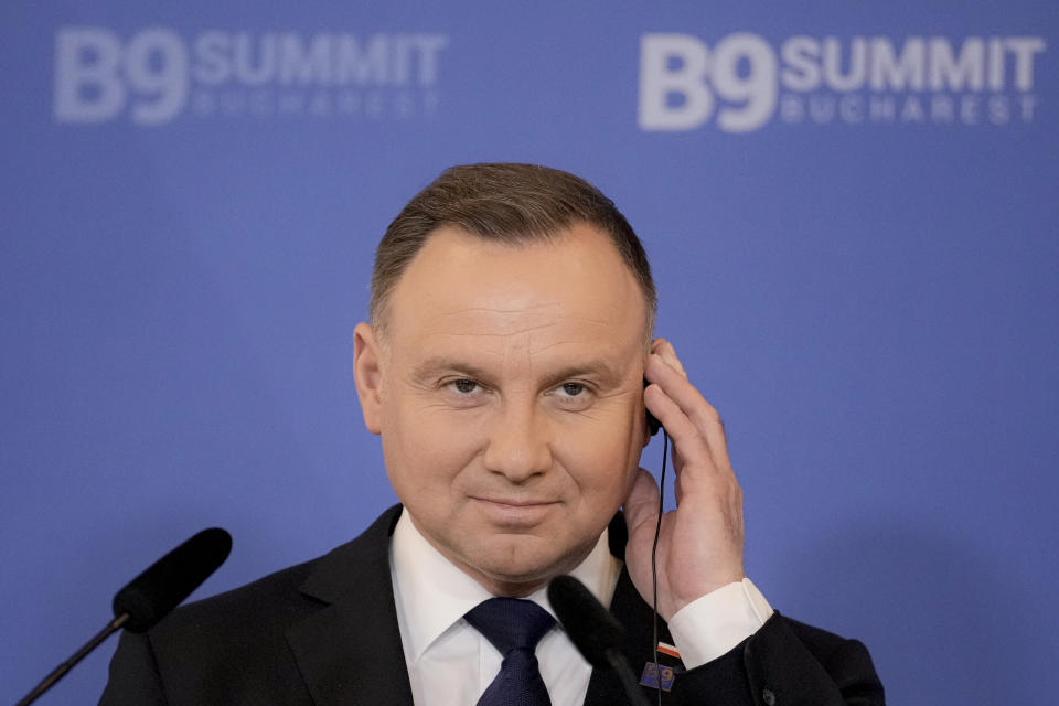 Polish President Andrzej Duda adjusts his headphones during press statements with Romania's President Klaus Iohannis at the end of the Bucharest Nine (B9) Summit at the Cotroceni Presidential Palace in Bucharest, Romania, Friday, June 10, 2022. (AP Photo/Andreea Alexandru)