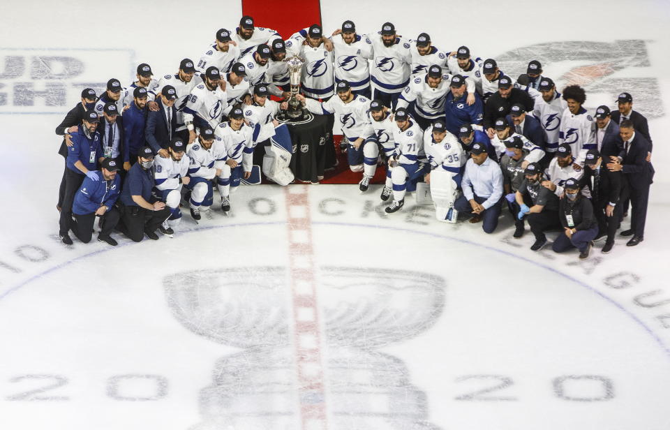Tampa Bay Lightning players and team members pose with the Prince of Wales trophy after the team's overtime win over the New York Islanders in Game 6 of the NHL hockey Eastern Conference final, Thursday, Sept. 17, 2020, in Edmonton, Alberta. (Jason Franson/The Canadian Press via AP)