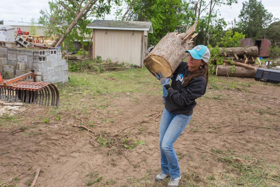 Kara Kent, of Gaylord, cleans a lot Sunday, May 22, 2022 in Gaylord, after a tornado touched down Friday. 