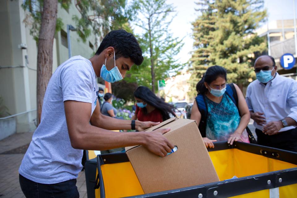 Akshay Talked, 18, loads up personal belongings in a cart with his family as he moves in on campus at the University of California, Berkeley on Aug. 16, 2021.