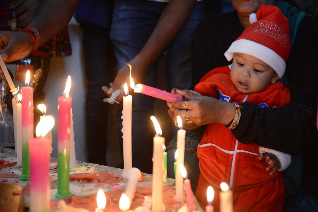 A young Indian Christian child is helped to light candles at St Paul's Church in Amritsar, India: Getty Images