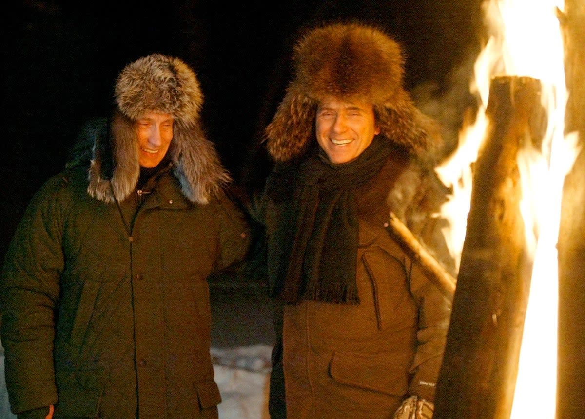 Russian President Vladimir Putin and Italian Prime Minister Silvio Berlusconi smile as they stand near a huge fire in a wildlife preserve and recreation area near a residence of Zavidovo, north-west of Moscow in February, 2003 (AFP/Getty)