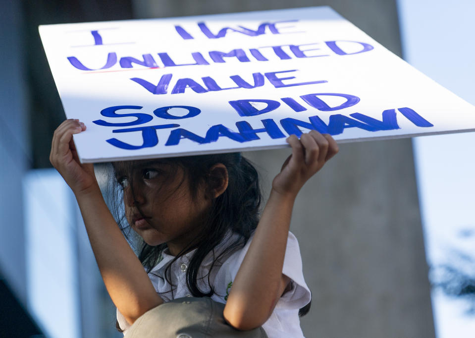 Layla Allibhai, 5, sits atop father Mo Allibhai's shoulders while holding a sign for Jaahnavi Kandula, a 23-year-old woman hit and killed in January by officer Kevin Dave in a police cruiser, as people protest after body camera footage was released of a Seattle police officer joking about Kandula's death, Thursday, Sept. 14, 2023, in Seattle. (AP Photo/Lindsey Wasson)