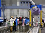 Employees prepare to begin work on a new set of 777X composite wing panel stringers during a media tour of the Boeing 777X Composite Wing Center at the Boeing production facility in Everett