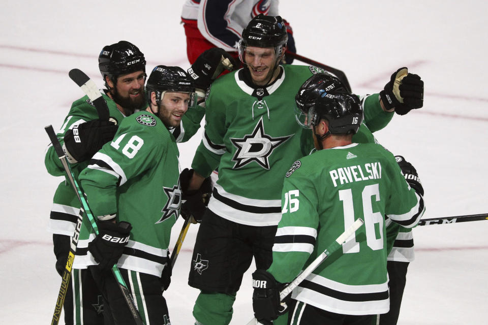 The Dallas Stars, including Jamie Benn (14), Jason Dickinson (18), Jamie Oleksiak (2) and Joe Pavelski (16) celebrate a second-period goal by Miro Heiskanen (4) against the Columbus Blue Jackets during an NHL hockey game on Thursday, April 15, 2021, in Dallas. (AP Photo/Richard W. Rodriguez)