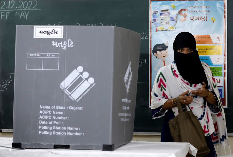 A woman leaves a polling booth after casting her vote, in Ahmedabad