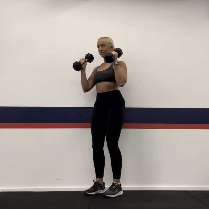 Personal trainer Klaudia Lucia demonstrating a biceps curl to shoulder press