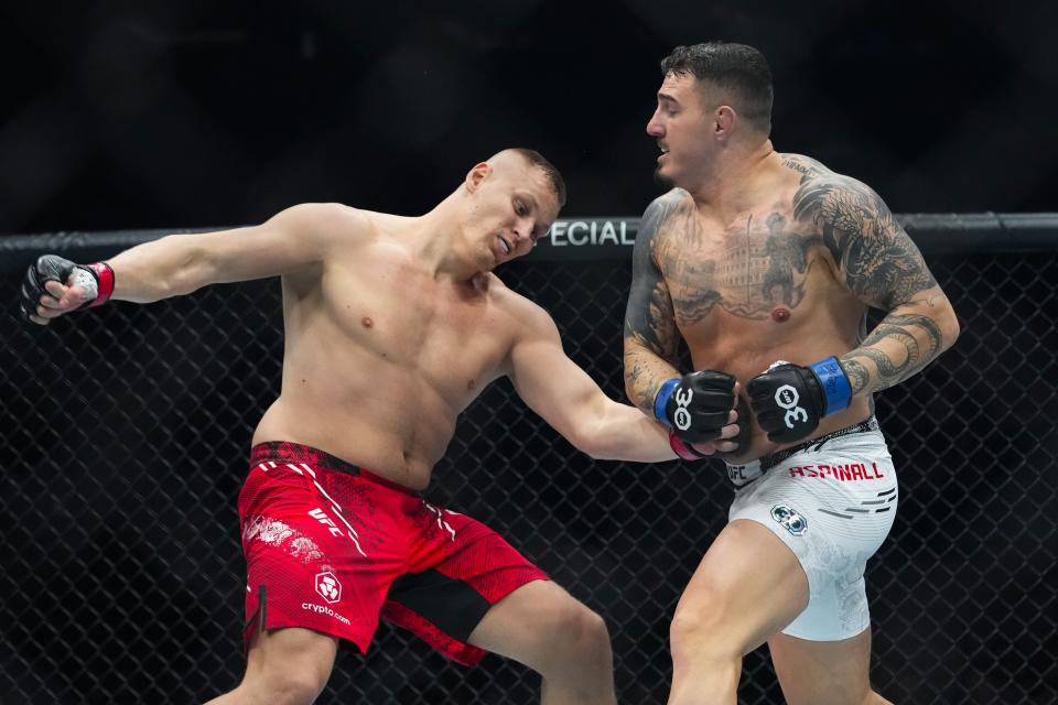 England's Tom Aspinall, right, knocks down Russia's Sergei Pavlovich during the first round of a heavyweight title bout at the UFC 295 mixed martial arts event Saturday, Nov. 11, 2023, in New York. Aspinall stopped Pavlovich in the first round. (AP Photo/Frank Franklin II)