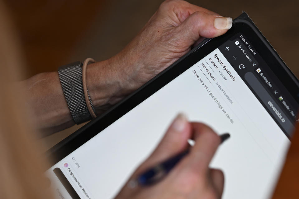 Rep. Jennifer Wexton, D-Va., uses an AI program on her iPad at her home in Leesburg, Va., Friday, July 19, 2024. A rare neurological disease robbed Wexton of her ability to speak clearly. But with the help of a powerful artificial intelligence program, the Virginia Democrat will use a clone of her voice to deliver what is believed to be the first speech on the House floor ever given via a voice cloned by artificial intelligence, thrusting Wexton into a broader debate about over artificial intelligence. (AP Photo/John McDonnell)