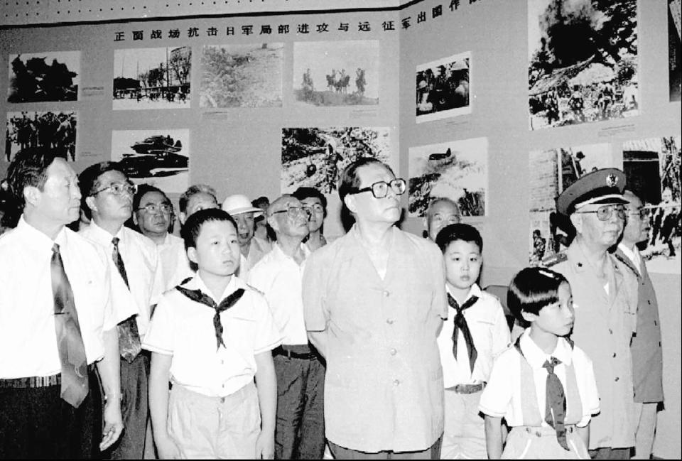 FILE - Then Chinese President Jiang Zemin, center, watches photos while he visits The Anti-Japanese Museum built beside Marco Polo Bridge in suburban Beijing to mark the 50th anniversary of the World War II, Aug. 15, 1995. Chinese state TV said Wednesday, Nov. 30, 2022, that Jiang has died at age 96. (Xinhua via AP, File)