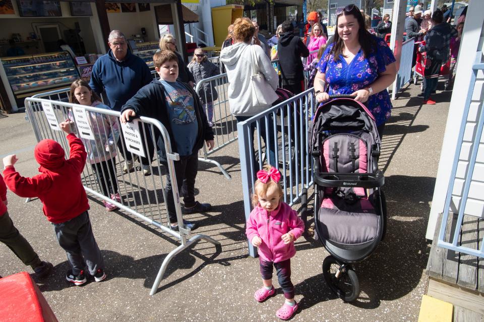 Members of the Nuhfert family, Scarlett, 1, at front, and her mother Shaunna, 28, stand on the ticket line, on May 7, 2022, a special preview day where season ticket holders come to get photo badges made and have a chance to ride a few of the rides at Waldameer Park and Water World in Erie. The family have not missed any years at the park, despite the pandemic.