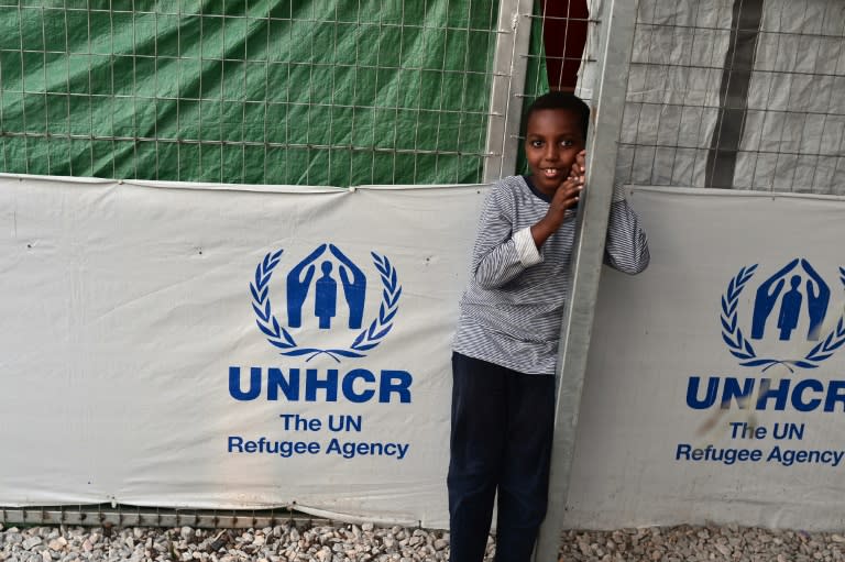 A child stands next to a UNHCR tent at the Kara Tepe migrant camp on the Greek island of Lesbos