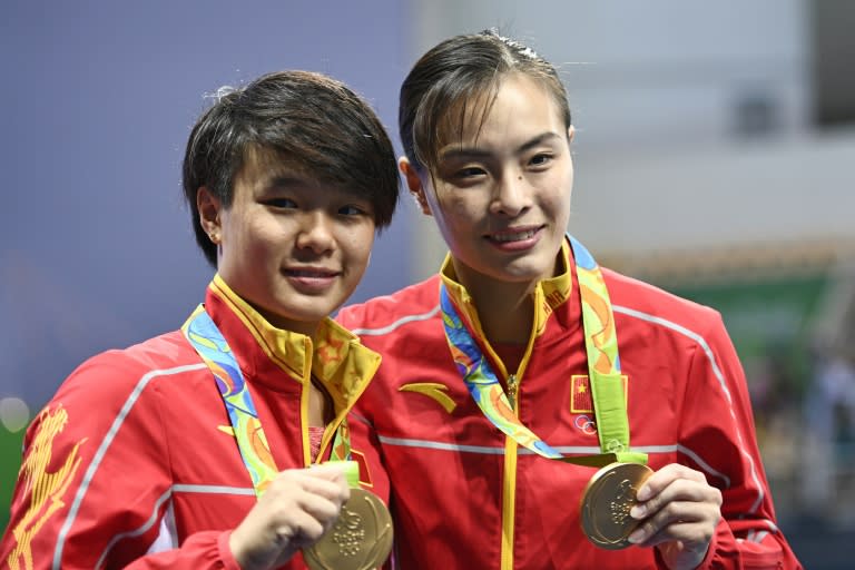 Gold medallists China's Wu Minxia (R) and Shi Tingmao pose after winning the women's synchronized 3m springboard final on August 7, 2016