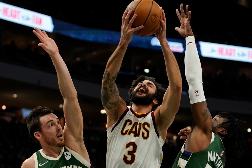 Cleveland Cavaliers' Ricky Rubio drives between Milwaukee Bucks' Wesley Matthews and Pat Connaughton during the first half of an NBA basketball game Monday, Dec. 6, 2021, in Milwaukee. (AP Photo/Morry Gash)