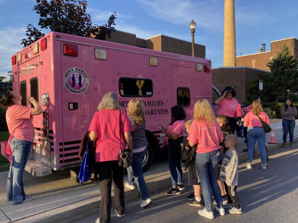 Participants at the Pink Light Walk line up to sign the pink ambulance before venturing the road to the Dale and Frances Hughes Cancer Center in East Stroudsburg on Oct. 6, 2022.