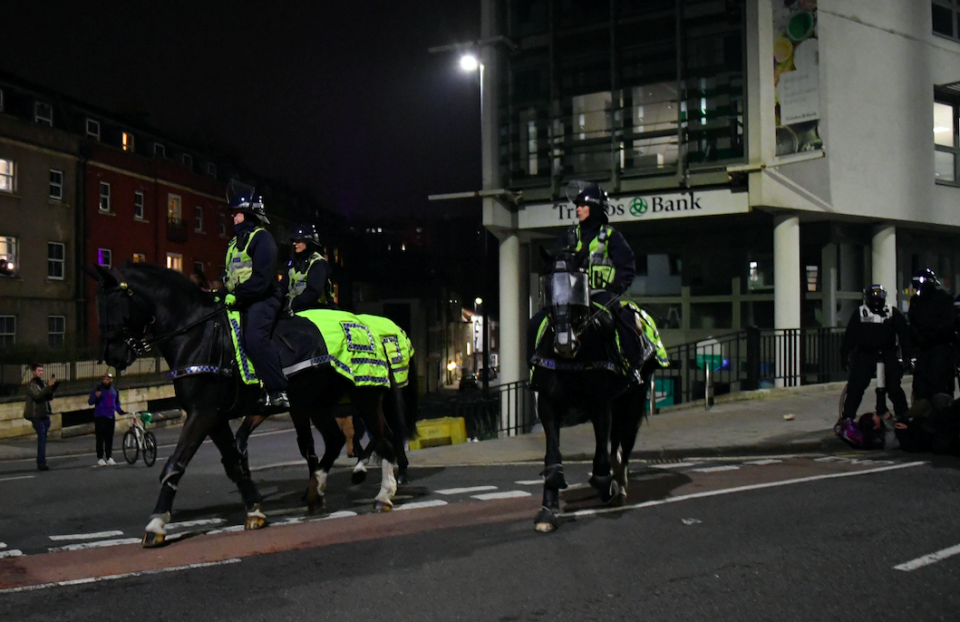 Officers on horseback patrol the streets of Bristol following another night of protests. (SWNS)