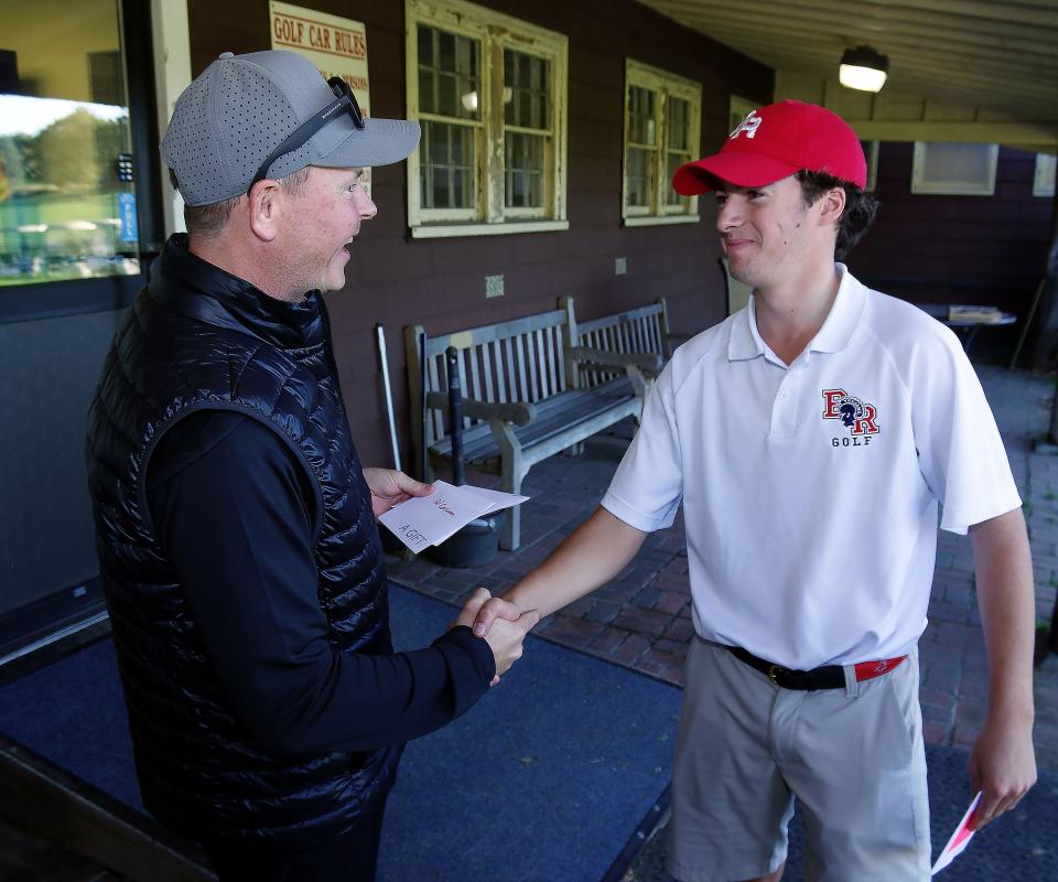 Brockton Golf Coach David Brophy gives a prize to Bridgewater-Raynham's Justin Peters for top play at the Sullivan Golf Tournament held at DW Field golf course in Brockton on Tuesday, Oct. 11, 2022. Peters led the Trojans to the overall team victory.