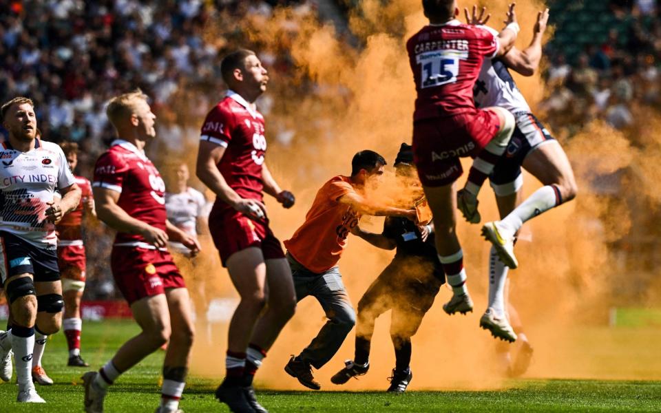 Just Stop Oil protester in cloud of orange powder tackles rugby player - Ben Stansall/AFP