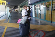 Umberto Andreani, 33, hugs his girlfriend Alice Tiberi, 27, who just arrived from Duesseldorf, Germany at Rome's Fiumicino airport, Wednesday, June 3, 2020. Rome’s Fiumicino airport sprang back to life on Wednesday as Italy opened regional and international borders in the final phase of easing its long coronavirus lockdown, allowing families and loved ones separated by the global pandemic to finally reunite. AP Photo/Alessandra Tarantino)