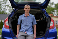 Caleb Jud, 33, poses for a portrait with his Honda Fit, Monday, May 13, 2024, in Cincinnati. Many Americans still aren’t sold on going electric for their next car purchase. High prices and a lack of easy-to-find charging stations are major sticking points, a new poll shows. Jud said he’s considering an EV, but may end up with a plug-in hybrid — if he goes electric. (AP Photo/Joshua A. Bickel)