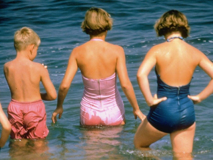 Young bathers (two girls, one boy) wadding out into the water at the beach on Martha's Vineyard off Cape Cod