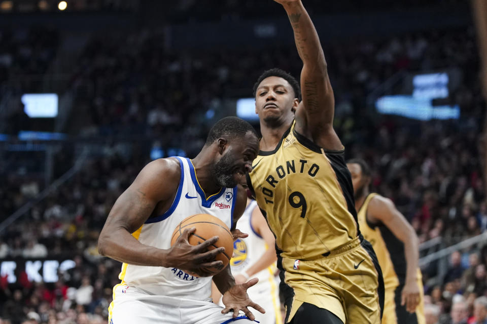 Golden State Warriors forward Draymond Green is defended by Toronto Raptors guard RJ Barrett (9) during the first half of an NBA basketball game Friday, March 1, 2024, in Toronto. (Arlyn McAdorey/The Canadian Press via AP)