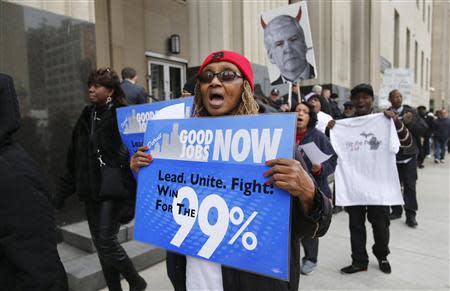 Protesters carry signs as they rally against cuts in city workers' pensions and the filing of the Municipal Bankruptcy, in front of the Federal Court House in Detroit, Michigan October 28, 2013. REUTERS/Rebecca Cook