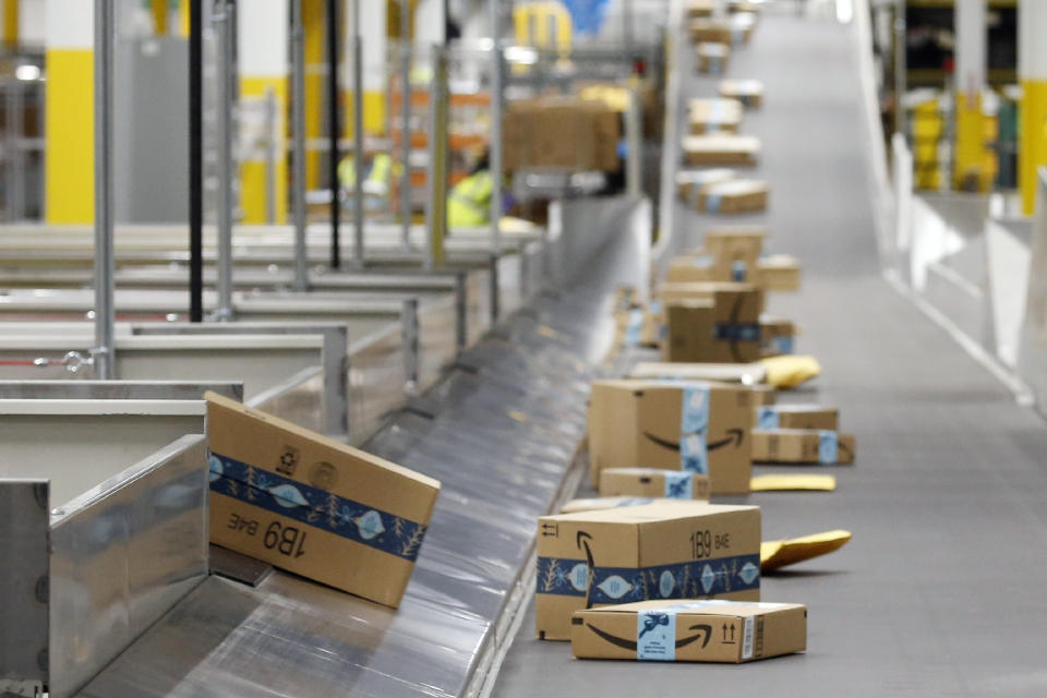 FILE - In this Dec. 17, 2019, file photo, Amazon packages move along a conveyor at an Amazon warehouse facility in Goodyear, Ariz. Amazon’s pandemic boom isn’t showing signs of slowing down. The company said Thursday, April 29, 2021, that its first-quarter profit more than tripled from a year ago, fueled by the growth of online shopping. It also posted revenue of more than $100 billion, the second quarter in row that the company has passed that milestone. (AP Photo/Ross D. Franklin, File)