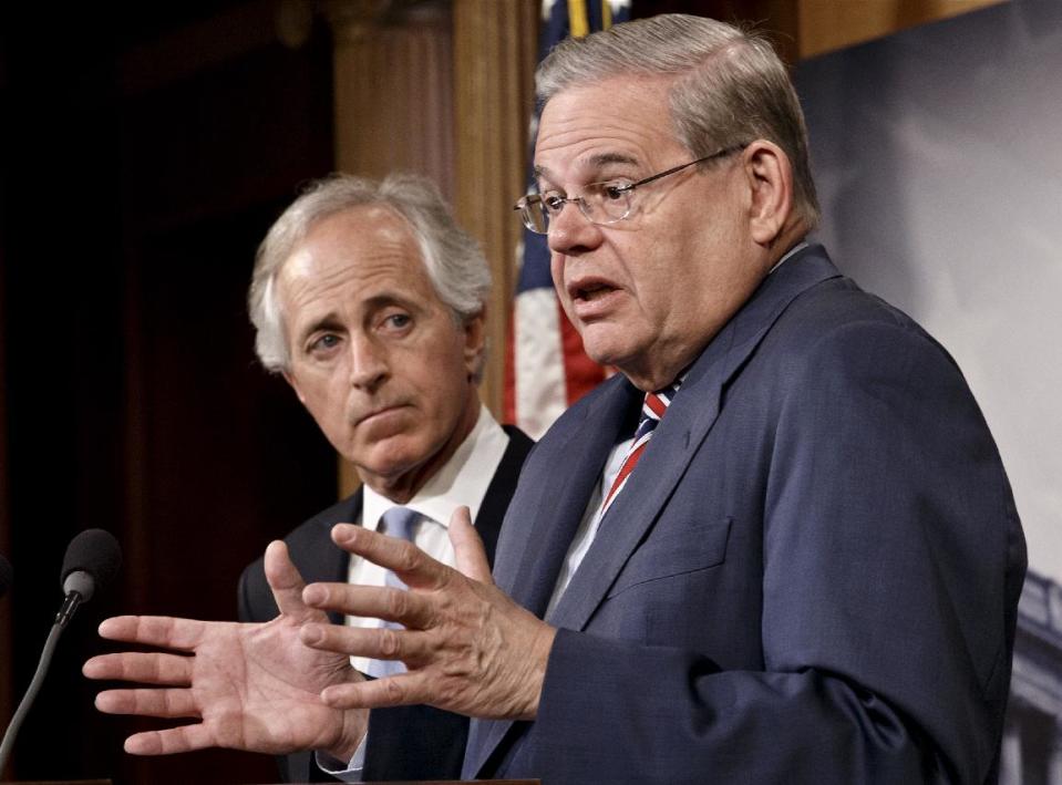 Senate Foreign Relations Committee Chairman Sen. Robert Menendez, D-N.J., accompanied by the committee's ranking member, Sen. Bob Corker, R-Tenn., gestures during a news conference on Capitol Hill in Washington, Thursday, March 27, 2014, just after the Senate passed the Ukraine Aid Bill in a show of support for the people of Ukraine and a get-tough message for Russian President Vladimir Putin for taking over the Crimea region. (AP Photo/J. Scott Applewhite)