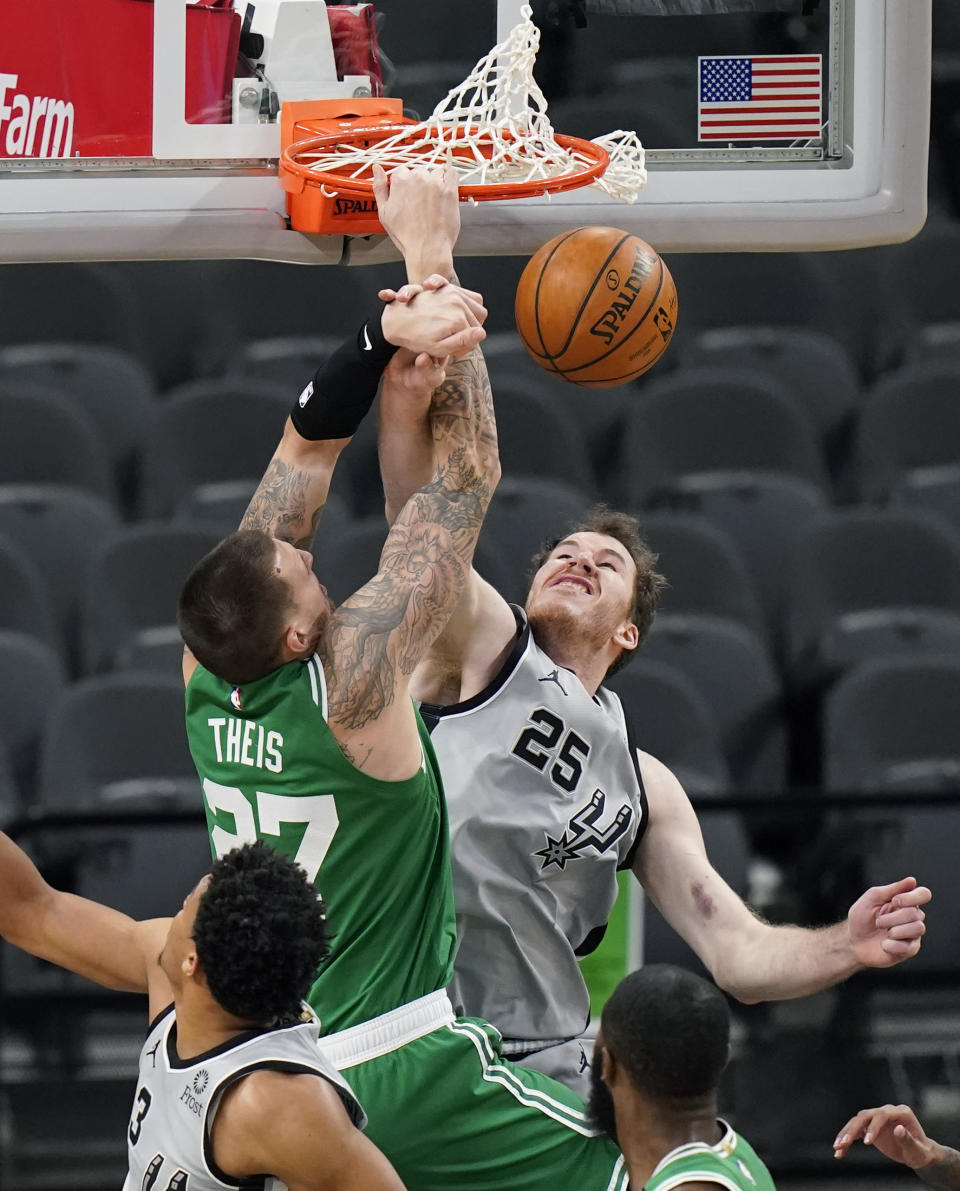 Boston Celtics center Daniel Theis (27) scores over San Antonio Spurs center Jakob Poeltl (25) during the second half of an NBA basketball game in San Antonio, Wednesday, Jan. 27, 2021. (AP Photo/Eric Gay)