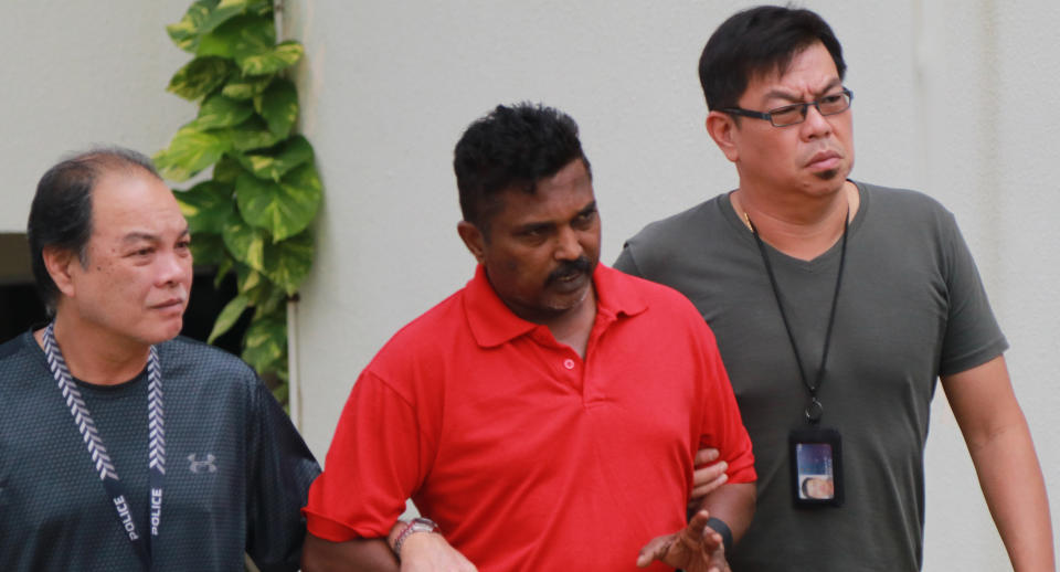 On 1 November 2017, Krishnan Raju (in red) was escorted by officers to the Loyang Gardens condominium on Jalan Loyang Besar where he allegedly killed 44-year-old Raithena Vaithena Samy. Photo: Yahoo News Singapore