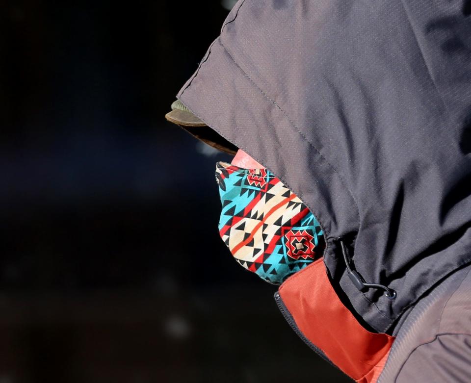 A man is bundled in layers and wearing a mask while walking in Market Square in Portsmouth Monday, Jan. 10, 2022.