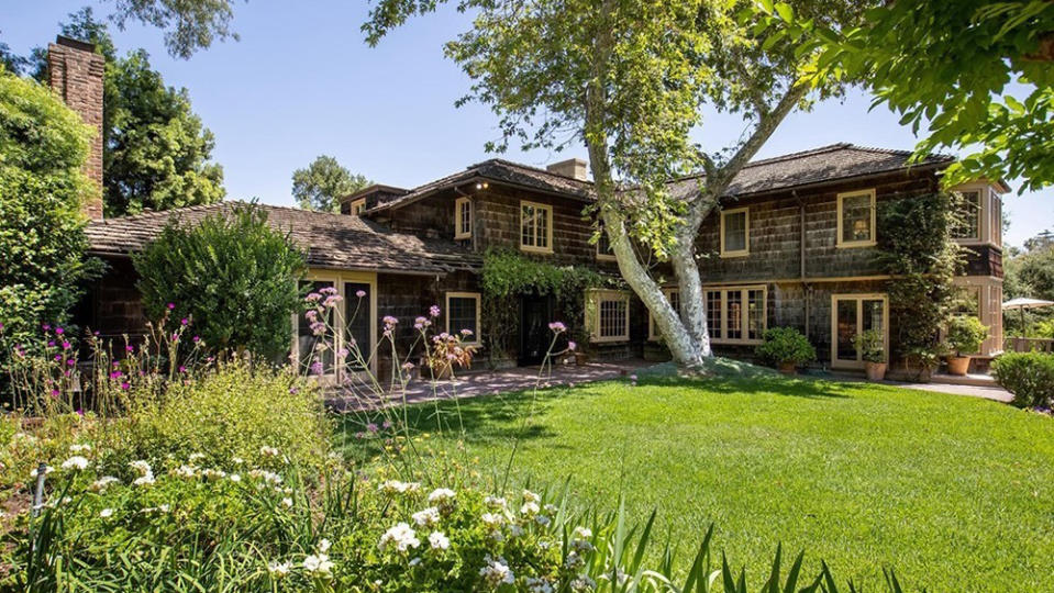 The front yard of home featuring a beautiful garden. - Credit: Redfin