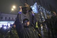 A man holds a part of a statue of Soviet state founder Vladimir Lenin which was toppled by protesters during a rally organized by supporters of EU integration in Kiev, December 8, 2013. Crowds toppled a statue of Soviet state founder Vladimir Lenin in the Ukrainian capital and attacked it with hammers on Sunday in the latest mass protests against President Viktor Yanukovich and his plans for closer ties with Russia. REUTERS/Maxim Zmeyev (UKRAINE - Tags: POLITICS CIVIL UNREST)