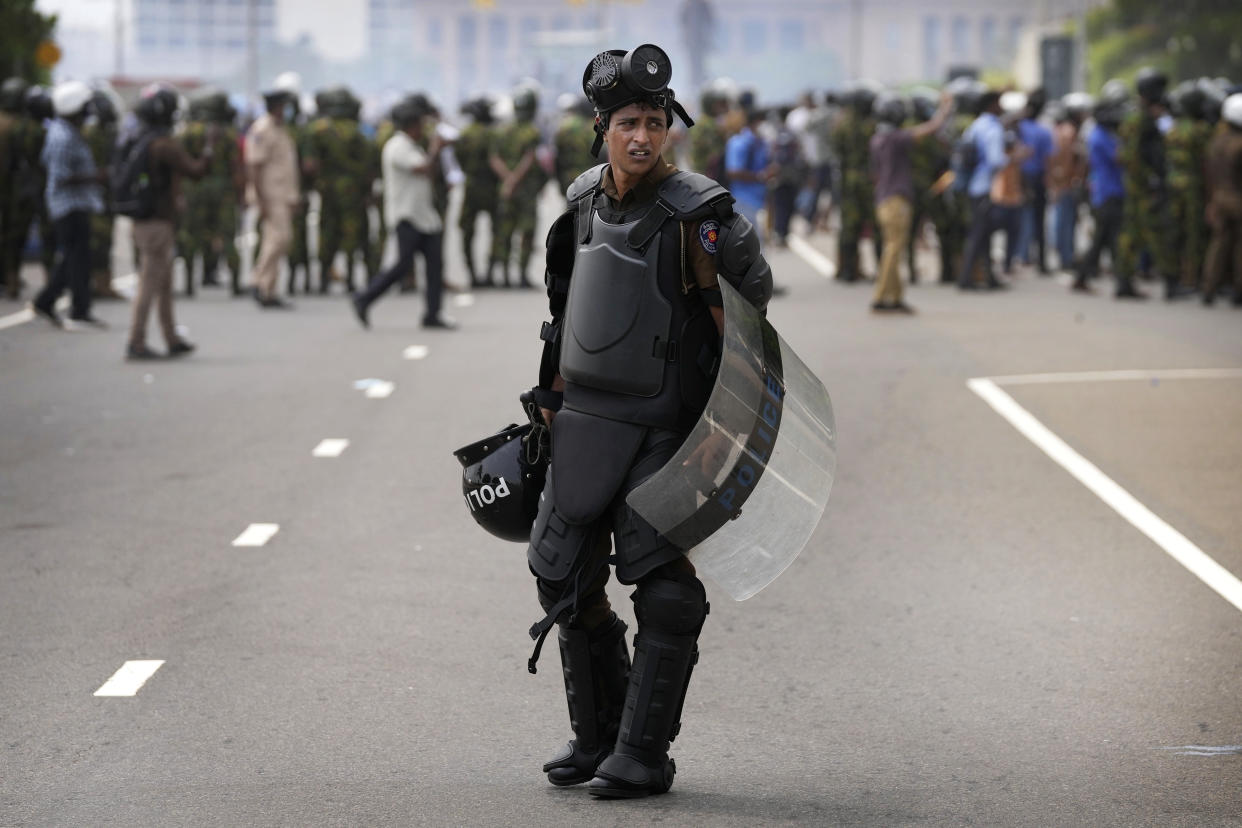 A Sri Lankan policeman stands guard in riot gear during clashes between anti-government protesters and government supporters in Colombo, Sri Lanka, Monday, May 9, 2022. Authorities deployed armed troops in the capital Colombo on Monday hours after government supporters attacked protesters who have been camped outside the offices of the country's president and prime minster, as trade unions began a “Week of Protests” demanding the government change and its president to step down over the country’s worst economic crisis in memory. (AP Photo/Eranga Jayawardena)