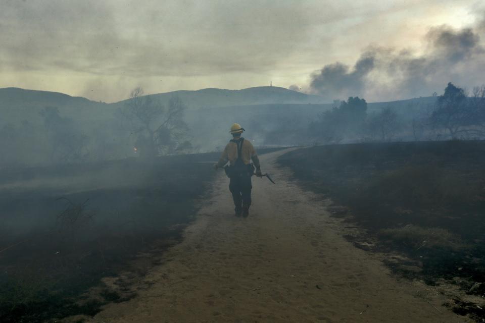 &nbsp;A fireman walks on trail looking for hotspots at Peters Canyon Regional Park in Orange, California.&nbsp;