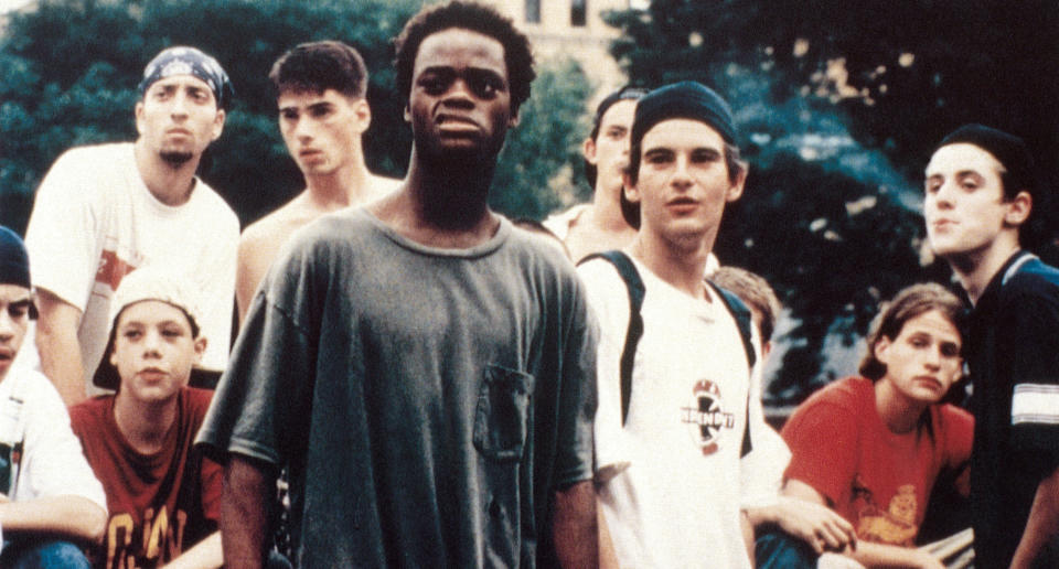 A group of teenage boys stand together, looking at something offscreen