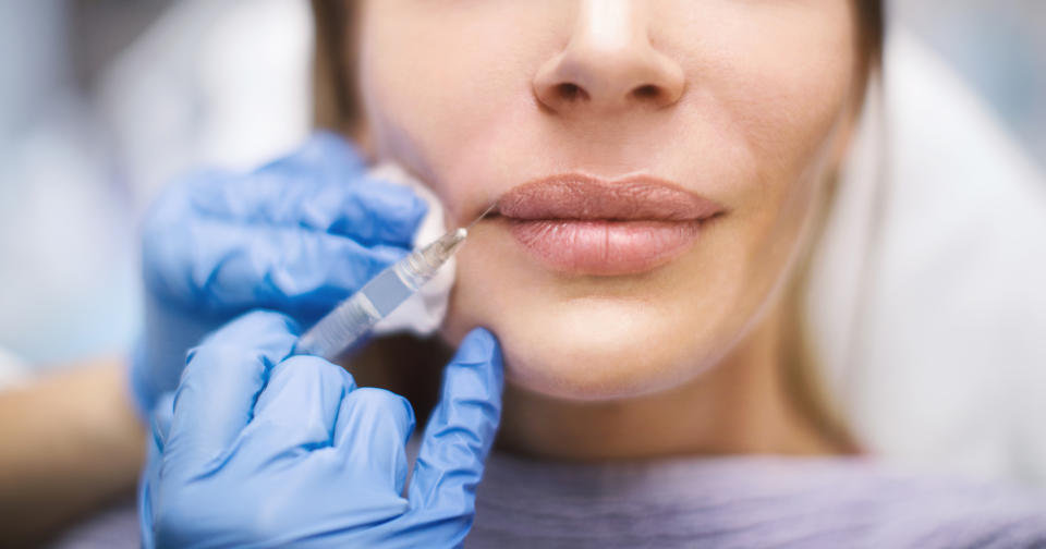 Unrecognizable woman having her lips enlarged at private medical clinic.