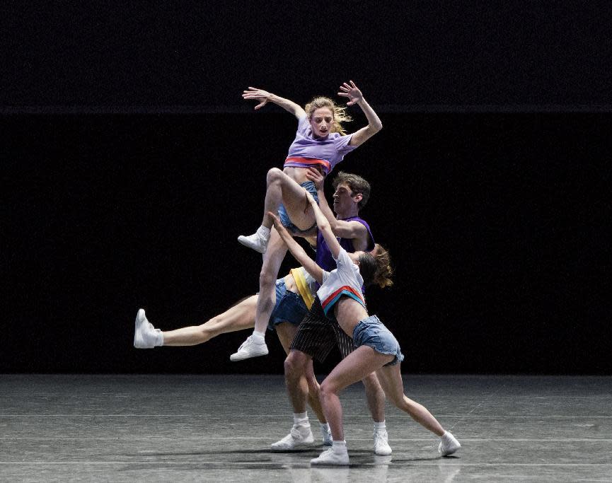 In this Jan 26, 2017 photo, Gretchen Smith, top, dances in Justin Peck’s "The Times Are Racing" in New York. Known for unconventional approaches to showing its clothes, the Opening Ceremony label swapped the runway entirely this Fashion Week for an evening at the ballet. The costumes, brightly colored urban streetwear, accompanied with sneakers rather than pointe shoes, were conceived by Opening Ceremony's Humberto Leon and NYCB's young star choreographer Peck. (Paul Kolnik/New York City Ballet via AP)